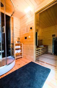 un sauna avec une douche et une grande fenêtre en verre dans l'établissement Willa ŻeglarSki, à Kluszkowce