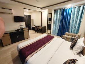 GK Residency Kailash Colony في نيودلهي: غرفة الفندق بسرير كبير ومكتب