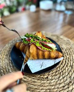 a person is eating a sandwich on a black plate at Lonca Butik Hotel in Giresun