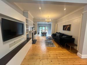ein Wohnzimmer mit einem großen Flachbild-TV an der Wand in der Unterkunft Large, Spacious Home in London with Modern Interior in Finchley