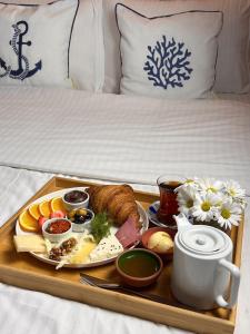 ギレスンにあるLonca Butik Hotelのベッドの上に朝食用の食品のトレイ