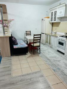 eine Küche mit einem Sofa und einem Tisch sowie eine Küche mit einem Kühlschrank in der Unterkunft Квартира в центре города,в ЖК Куралай in Qysylorda