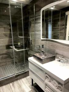 ein Bad mit einem Waschbecken und einer Dusche in der Unterkunft Hôtel La Réserve in Gérardmer