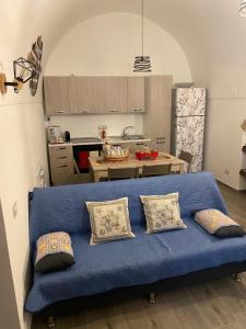 un sofá azul con almohadas en la cocina en Casa Giovannina, en Bernalda