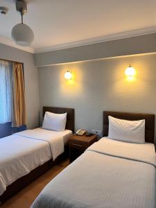 ギレスンにあるLonca Butik Hotelのホテルルーム 白いシーツ付きのベッド2台付