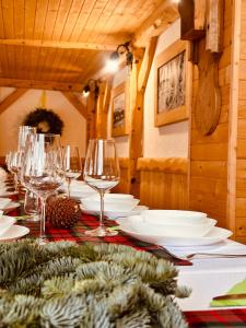 a table with wine glasses and plates on it at Gospodarstwo Agroturystyczne Baciary DOMEK W GORACH in Klikuszowa