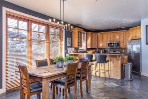 a kitchen with a wooden table and chairs and a refrigerator at Town Pointe A105 in Park City
