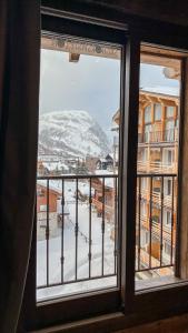 a window with a view of a snow covered mountain at RESIDENCE GRAND COCOR -Studio 25 m2- in Val-d'Isère