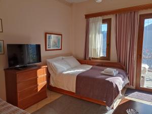 ein Schlafzimmer mit Bett und Flachbildfernseher in der Unterkunft LOUNA in Metsovo