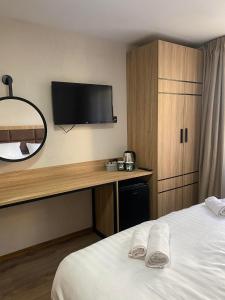 a hotel room with a bed and a desk with a tv at Deers in Bansko