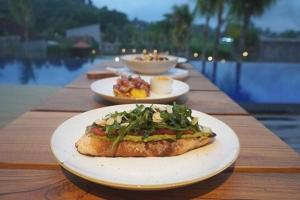 a table with three plates of food on it at sayana bali in Gianyar