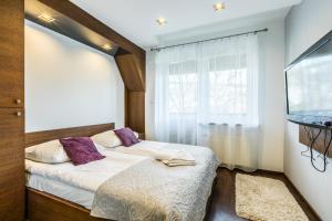 niewielka sypialnia z łóżkiem i oknem w obiekcie Apartament Levante w Zakopanem