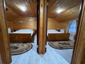 ヤレムチャにあるКотедж "ГІРСЬКА РОСА" Яремче Чан Басейн Саунаのベッド2台 木製の壁の部屋