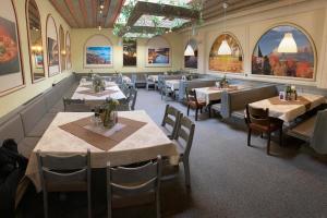 a restaurant with tables and chairs and paintings on the walls at Ferienwohnung Gfrerer Althofen in Mariapfarr