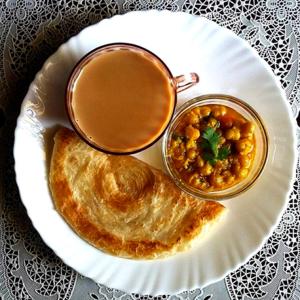 a plate of food with a cup of coffee and bread at GK Residency Kailash Colony in New Delhi