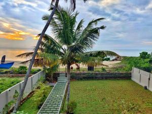 a stairway leading down to a beach with palm trees at SHORE STORIES in Alleppey