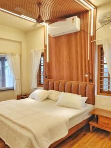 sypialnia z dużym łóżkiem z białą pościelą w obiekcie SHORE STORIES w mieście Alappuzha