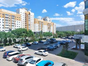un estacionamiento lleno de coches en una ciudad en Апартаменты-студия 2day apart в районе Байтерека, en Astana
