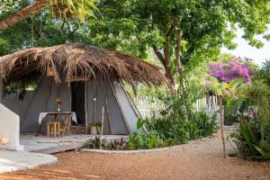 uma pequena cabana com telhado de palha num jardim em Bahaka Jeri em Jericoacoara