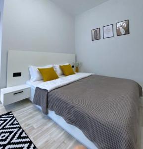 1 dormitorio con 1 cama con almohadas amarillas y blancas en Апартаменты-студия 2day apart в районе Байтерека, en Astana