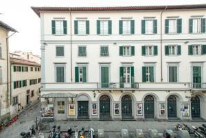 フィレンツェにあるMamo Florence - Verdi Apartmentの緑のシャッター付き白い大きな建物