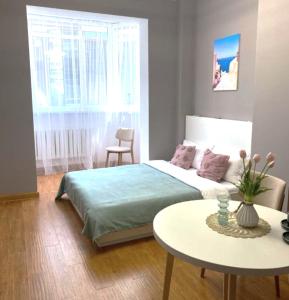 Dormitorio pequeño con cama y mesa en Апартаменты-студия 2day apart в районе Байтерека, en Astana