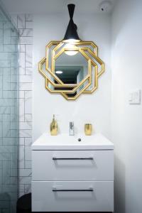 a bathroom with a sink and a mirror on the wall at Apart David przy Rynku - Parking by #Hoomvi in Wrocław