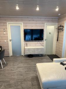 1 dormitorio con TV de pantalla plana en la pared en Villa Lilla en Porvoo