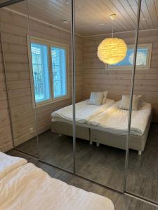 a bedroom with two beds and a mirror at Villa Lilla in Porvoo