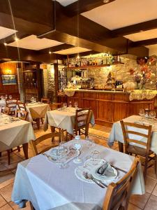 a restaurant with white tables and chairs and a kitchen at Hotel Stella Del Nord in Courmayeur