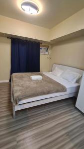 - une chambre avec un grand lit et un rideau bleu dans l'établissement AVIDA Riala T4-2010, à Cebu