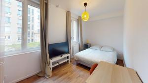 een slaapkamer met een bed, een tv en een raam bij Immeuble COTY Jacuzzi studios et chambres in Le Havre