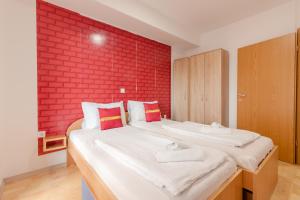 1 dormitorio con 1 cama grande y pared de ladrillo rojo en Apartment Bravo Boulevard, en Ohrid
