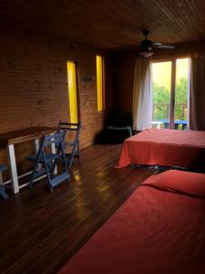 a bedroom with a bed and a table and a window at Las Alquimillas apart -a 70 metros de la playa- in Punta Del Diablo