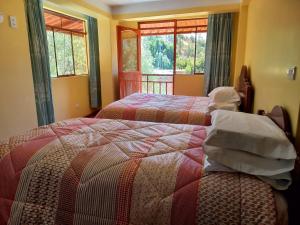 a bedroom with two beds and a window at Fundo San Silvestre in Huaraz +42 photos