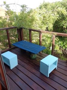 a blue picnic table and two stools on a deck at Las Alquimillas apart -a 70 metros de la playa- in Punta Del Diablo