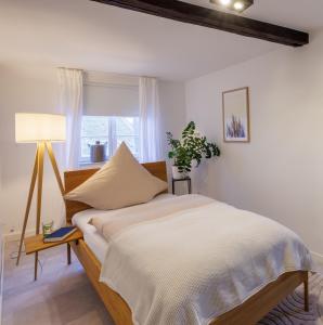 um quarto com uma cama com um candeeiro e uma janela em Romantisches Apartment mit Whirlpool in Bayreuther Fußgängerzone em Bayreuth
