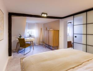 a bedroom with a bed and a desk and a table at bayreuthome - Romantisches City Apartment mit Whirlpool - 2 Schlafzimmer- mobiles Klimagerät in Bayreuth