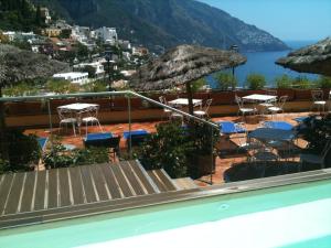 a view of a swimming pool with chairs and umbrellas at Hotel Posa Posa in Positano
