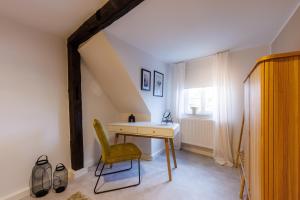 Cette chambre dispose d'un bureau, d'une chaise et d'une fenêtre. dans l'établissement Romantisches Apartment mit Whirlpool in Bayreuther Fußgängerzone, à Bayreuth