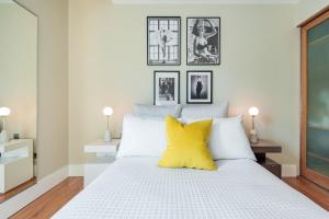 um quarto com uma cama branca e almofadas amarelas em Welcome London Piccadilly Circus em Londres