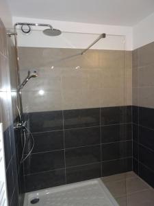 um chuveiro com uma porta de vidro na casa de banho em Espace Sainte-Maxime em Sainte-Maxime