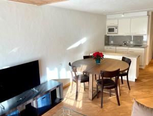 a kitchen and dining room with a table and chairs at Apartment Gstaaderhof in Gstaad