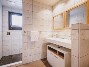 a white bathroom with a sink and a mirror at Appartements Enzian by we rent in Rauris
