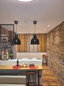 a kitchen with two pendant lights and a brick wall at ladadikathess in Thessaloniki