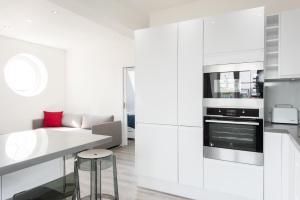 a kitchen with white cabinets and a stove top oven at Welcome London Carnaby Street in London