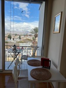 balcón con mesa y sillas y ventana grande en Nicosia City Centre Sky Views Apartment, en Nicosia