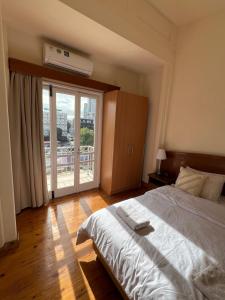um quarto com uma cama grande e uma janela grande em Nicosia City Centre Sky Views Apartment em Nicósia