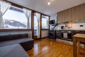 a living room with a couch and a kitchen at Appartamento Lorenzo in Livigno