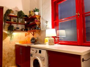ブダペストにあるSophia Last Minute Apartmentsのキッチン(洗濯機、赤いキャビネット付)